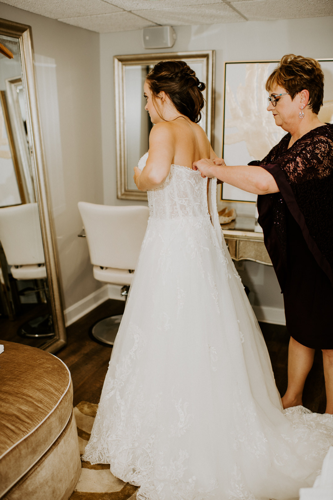 Bride getting ready in wedding dress: Romantic Nashville Wedding at The Bedford featured on Nashville Bride Guide