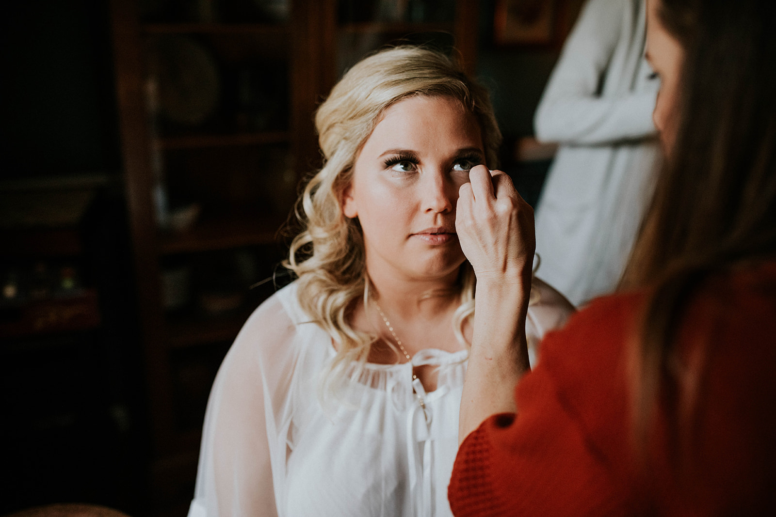 Bride getting makeup done for wedding day