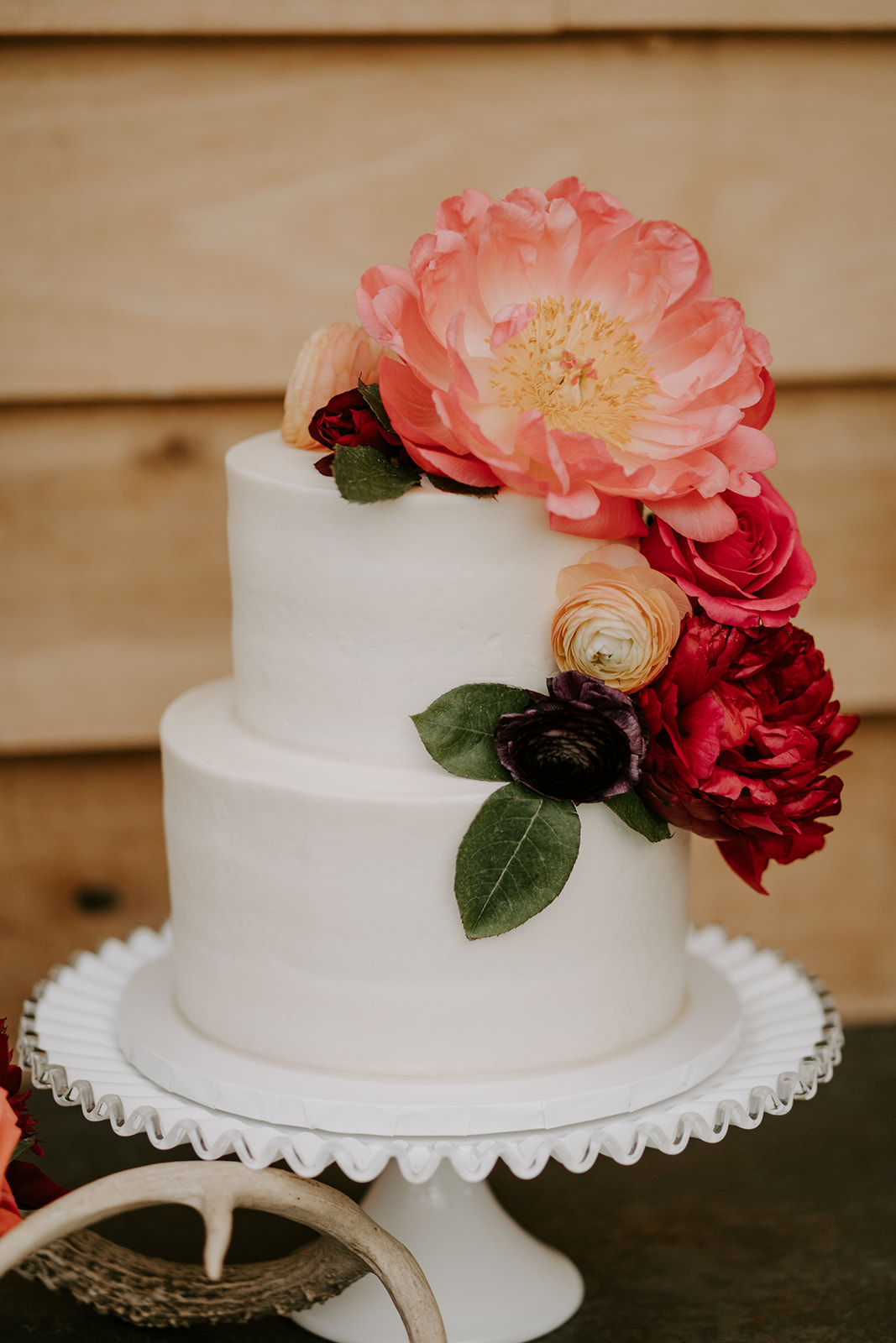 White wedding cake with pink and red flowers