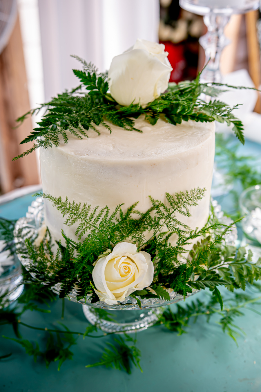 Small white wedding cake with greenery